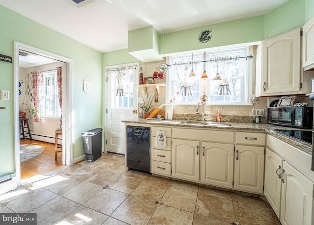 kitchen featuring black appliances, baseboard heating, plenty of natural light, and a sink