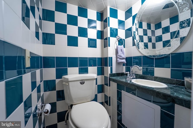 half bathroom featuring toilet, decorative backsplash, tile walls, and vanity