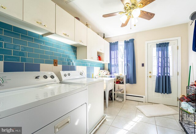 laundry area featuring cabinet space, a ceiling fan, baseboard heating, separate washer and dryer, and light tile patterned flooring