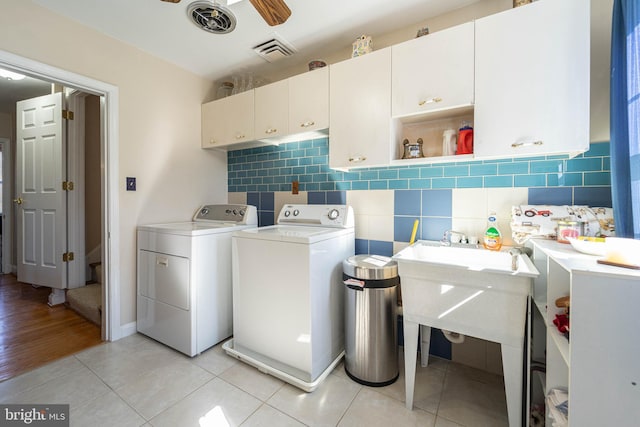 laundry room featuring cabinet space, independent washer and dryer, visible vents, and light tile patterned floors