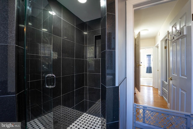 full bath with wood finished floors and a shower stall