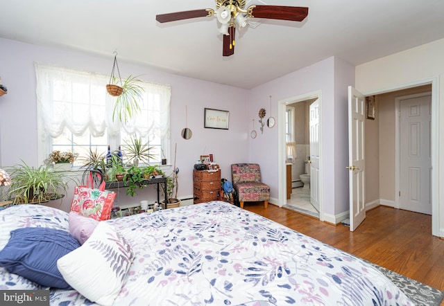 bedroom featuring a baseboard radiator, a ceiling fan, connected bathroom, wood finished floors, and baseboards