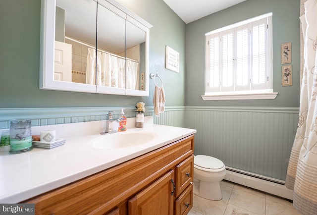 full bath with a wainscoted wall, a baseboard radiator, toilet, vanity, and tile patterned flooring