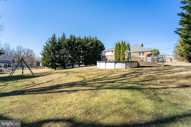 view of yard featuring a covered pool and a wooden deck