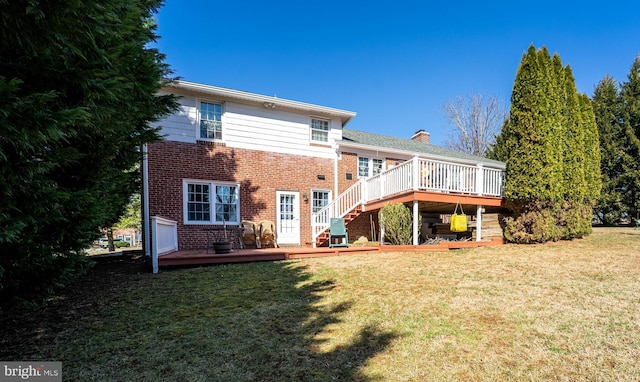 rear view of house featuring stairway, brick siding, a yard, and a deck