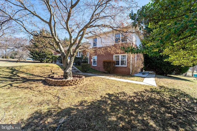 traditional-style house with a front yard and brick siding