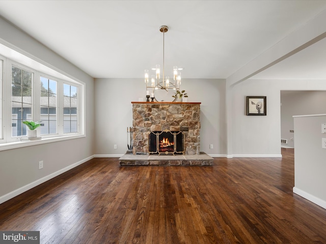 unfurnished living room featuring baseboards, a chandelier, hardwood / wood-style flooring, and a fireplace