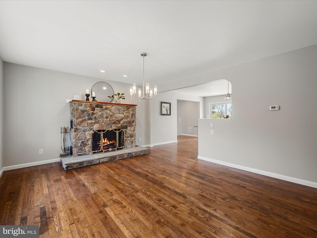 unfurnished living room with baseboards, hardwood / wood-style flooring, and a fireplace