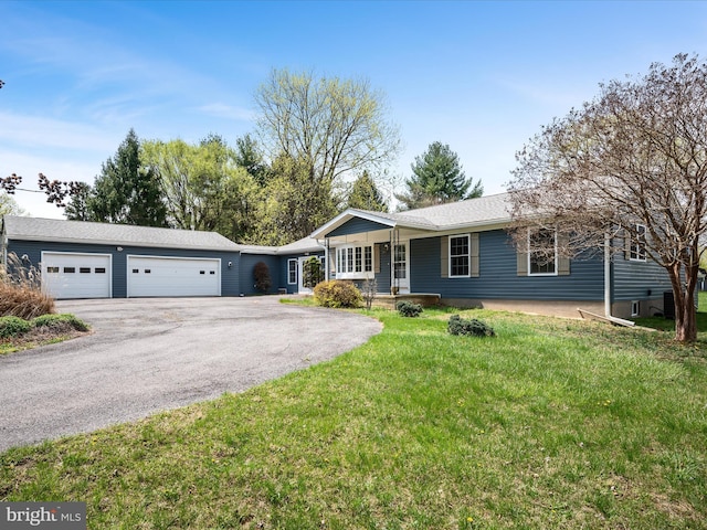 single story home featuring a front yard, a garage, and driveway