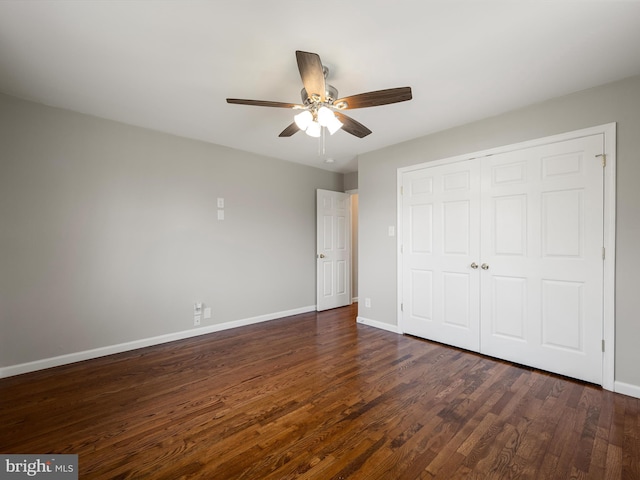 unfurnished bedroom featuring dark wood-type flooring, a closet, ceiling fan, and baseboards