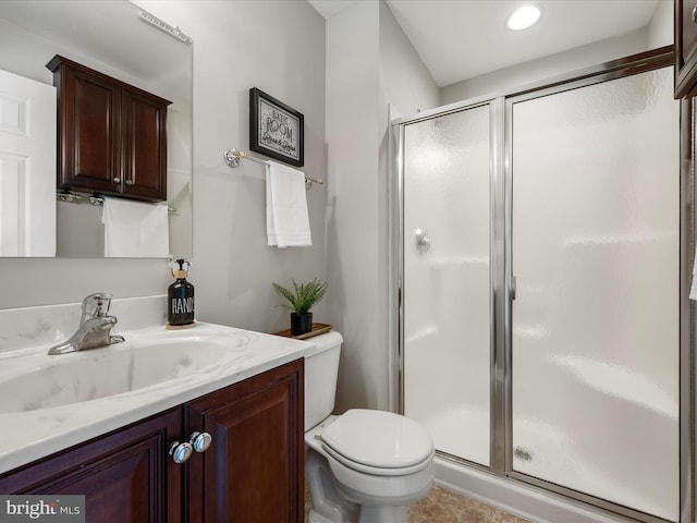 bathroom featuring toilet, a shower stall, and vanity
