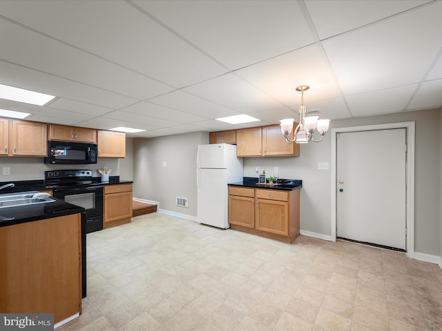 kitchen with visible vents, baseboards, a sink, dark countertops, and black appliances