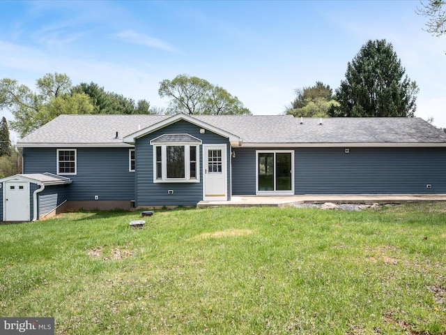 rear view of property featuring a yard, a storage shed, an outbuilding, and a patio area