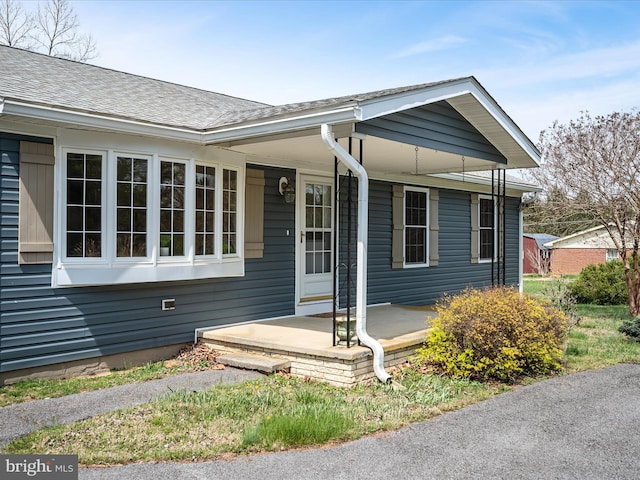 view of front of house with roof with shingles and covered porch