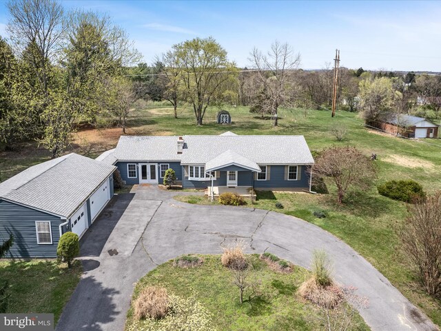 view of front of property featuring an attached garage, french doors, driveway, and a front yard