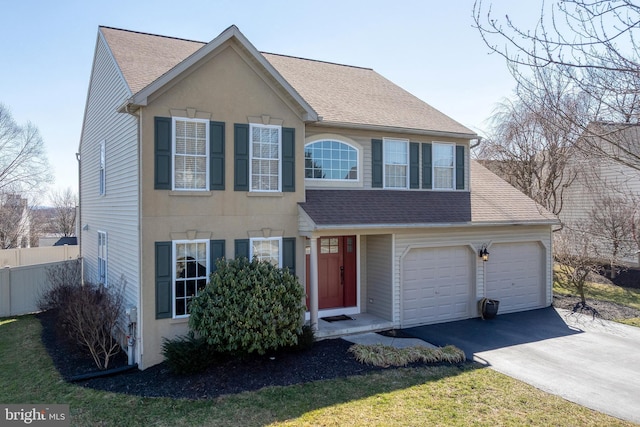 view of front of home with driveway, roof with shingles, fence, and stucco siding