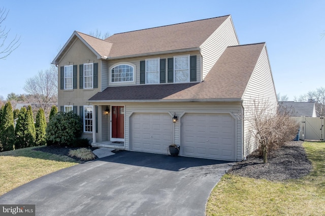 view of front of property featuring an attached garage, a front lawn, aphalt driveway, and roof with shingles