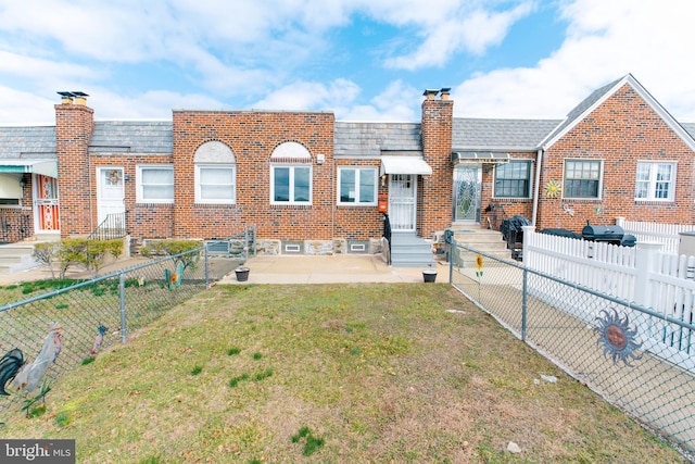 townhome / multi-family property with a patio, a chimney, entry steps, a front yard, and fence private yard