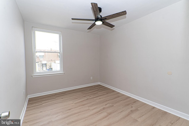 spare room with a ceiling fan, light wood-type flooring, and baseboards