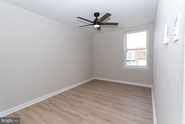 spare room featuring light wood-style flooring, baseboards, and ceiling fan