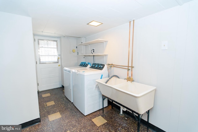 laundry room featuring laundry area, washing machine and dryer, a sink, and tile patterned floors