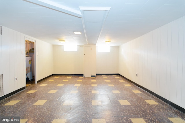 below grade area with water heater, tile patterned floors, and baseboards