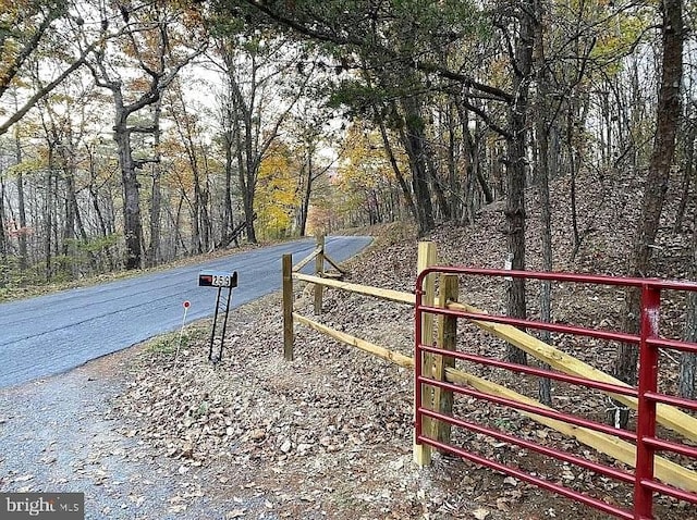 view of gate with a forest view