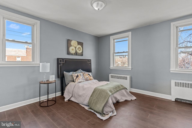 bedroom with dark wood finished floors, radiator, and baseboards