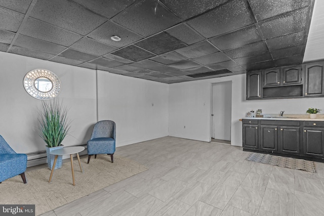 sitting room featuring a drop ceiling and a baseboard heating unit