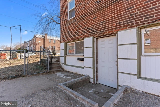 exterior space with brick siding, fence, and a gate