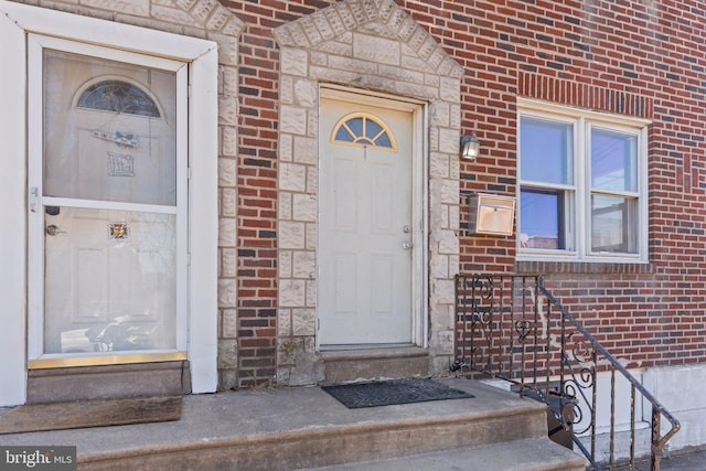 entrance to property featuring brick siding