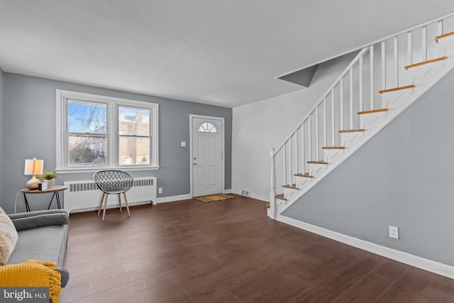 entrance foyer with stairs, radiator, wood finished floors, and baseboards