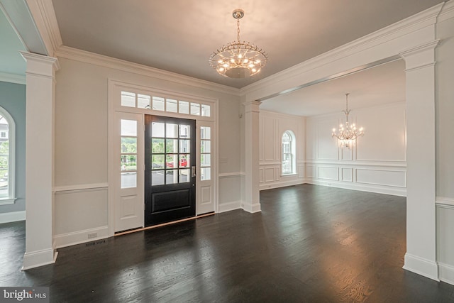 entryway featuring dark wood-style floors, a notable chandelier, decorative columns, a decorative wall, and ornamental molding