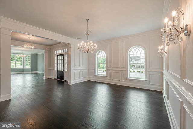 interior space featuring dark wood-style floors, a chandelier, and a decorative wall