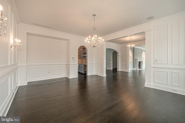 unfurnished room with arched walkways, a decorative wall, and a notable chandelier