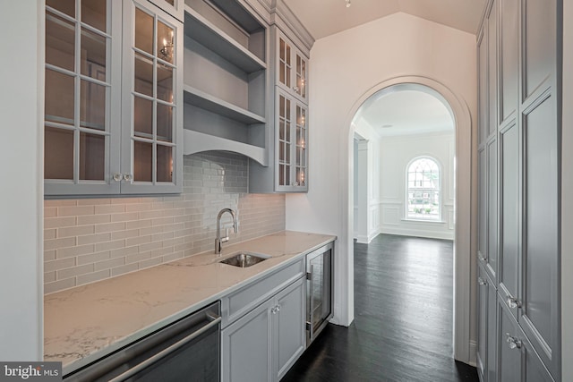 kitchen featuring dishwasher, lofted ceiling, dark wood-style floors, wine cooler, and light stone countertops