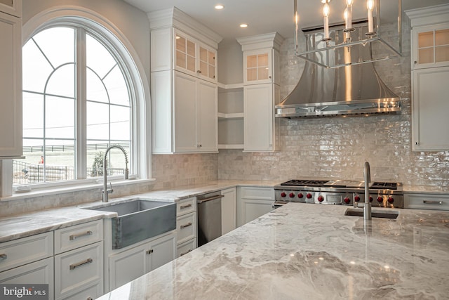 kitchen featuring a sink, wall chimney range hood, decorative backsplash, and open shelves