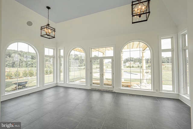 unfurnished sunroom with lofted ceiling and a notable chandelier