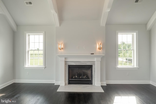 unfurnished living room with beamed ceiling, a fireplace, visible vents, and baseboards