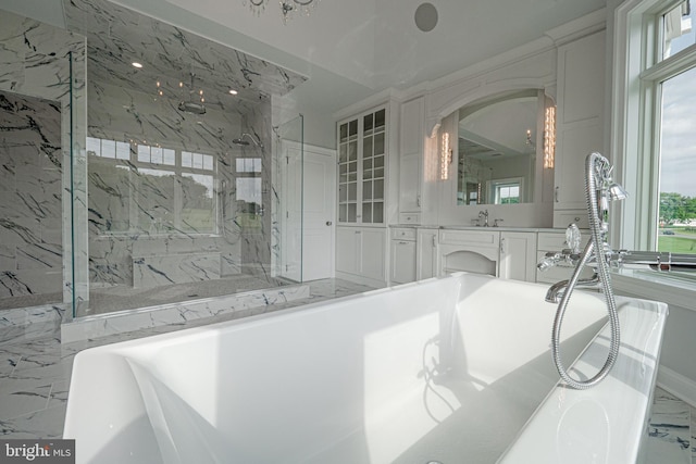 full bathroom featuring marble finish floor, a freestanding tub, a marble finish shower, and vanity