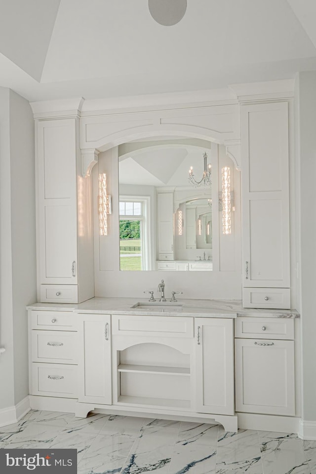 bathroom featuring marble finish floor, baseboards, vaulted ceiling, and vanity