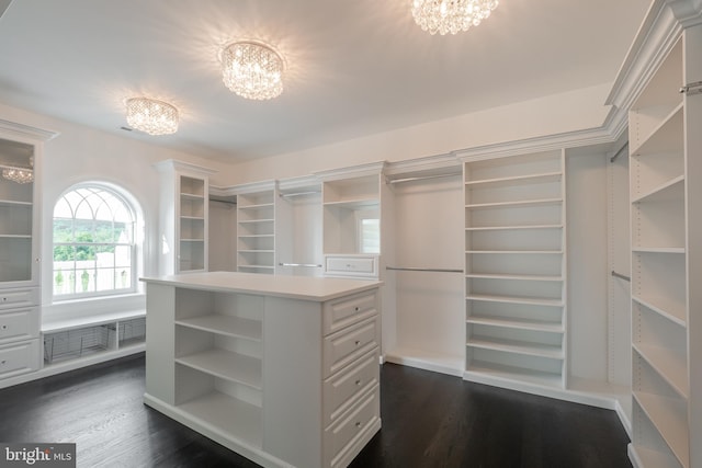 spacious closet featuring dark wood-style floors and an inviting chandelier