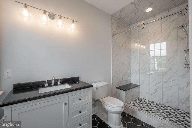 bathroom featuring toilet, vanity, and a marble finish shower