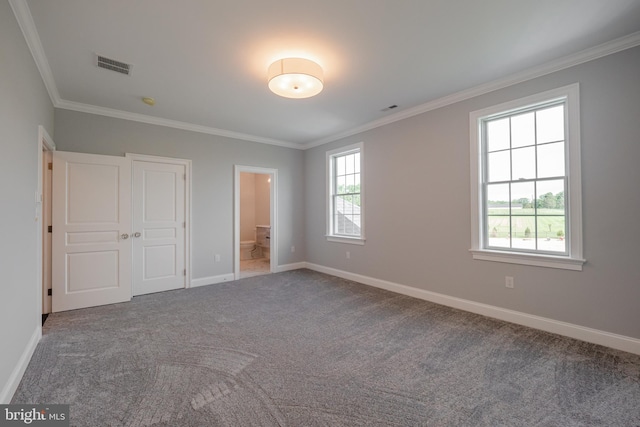 unfurnished bedroom featuring carpet floors, ornamental molding, visible vents, and baseboards