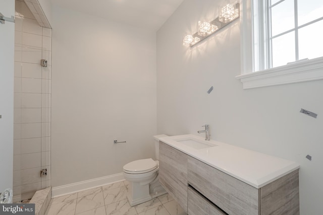 bathroom with marble finish floor, toilet, vanity, and baseboards