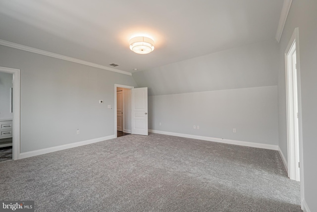 unfurnished bedroom featuring baseboards, visible vents, lofted ceiling, ornamental molding, and carpet floors