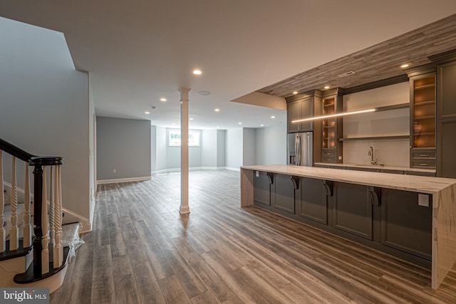 interior space featuring stainless steel refrigerator with ice dispenser, recessed lighting, dark wood-type flooring, a sink, and stairs