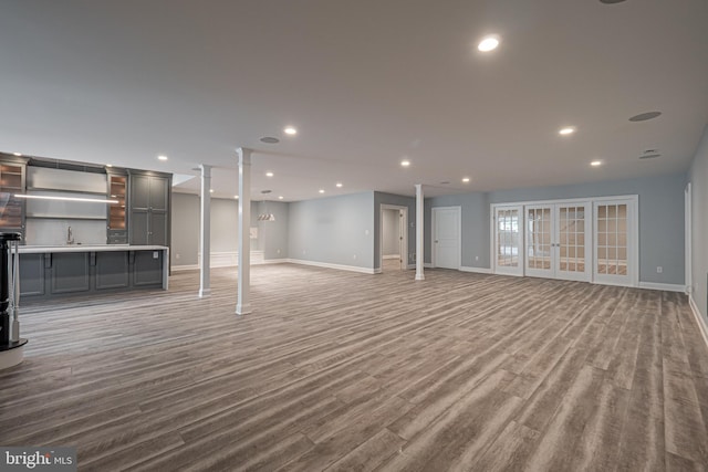 basement featuring baseboards, wood finished floors, and recessed lighting