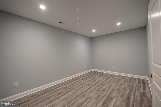 unfurnished room with recessed lighting, wood finished floors, visible vents, and baseboards