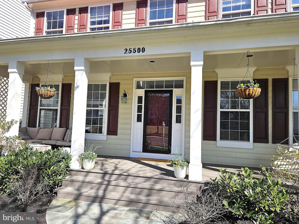 view of exterior entry featuring covered porch